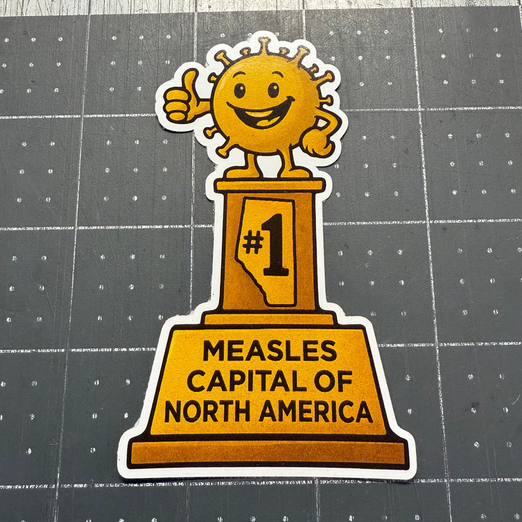 Sticker with a measles designand text on a gray cutting mat 