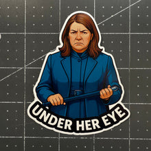 Sticker of a person in a blue coat with 'Under Her Eye' text on a grid background
