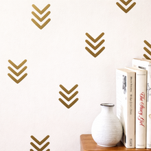 Decorative wall with gold arrow patterns and books on a shelf.