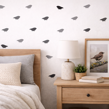 Bedroom with bird wall decals and a framed picture on the nightstand.