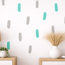 Decorative wall with abstract green and gray paint strokes, lamp, plant, and vase on a shelf.