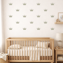 Nursery room with wooden crib, decorative wall stickers, and side table.