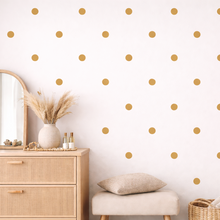 Room interior with wooden dresser, mirror, and polka dot wall design.