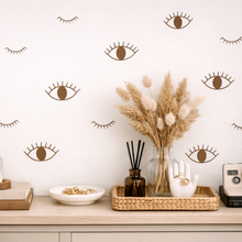Decorative wall with eye and crescent moon patterns, featuring a shelf with decorative items.