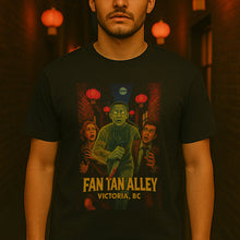 Person wearing a black t-shirt with 'Fan Tan Alley' design in a dimly lit room with red lanterns.