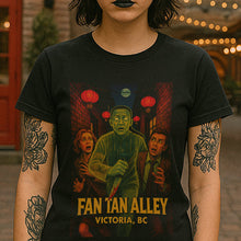 Person wearing a black t-shirt with a graphic design and text, standing in front of a brick building with red doors.