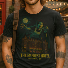 Person wearing a black t-shirt with 'The Empress Hotel' design, standing outdoors.