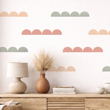 Wall with geometric pattern, wooden console table with decor items, and plants.