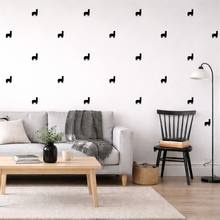 Modern living room with white walls, gray sofa, wooden coffee table, and decorative wall stickers.