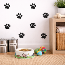 Pet accessories including a bowl, toys, and storage bins with paw print decals on the wall.