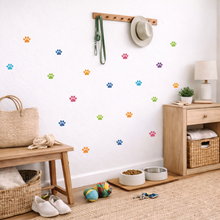 Entryway with wooden bench, baskets, pet bowls, and colorful paw prints on the wall.