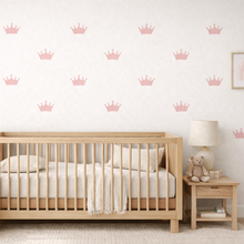 Nursery room with wooden crib, decorative wall stickers, and side table.