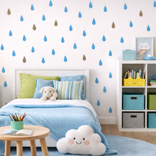Wallpaper with blue and brown raindrop pattern and a green pillow on a white background