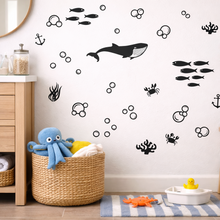Children's bathroom with wall decals of sea creatures, baskets, and toys.